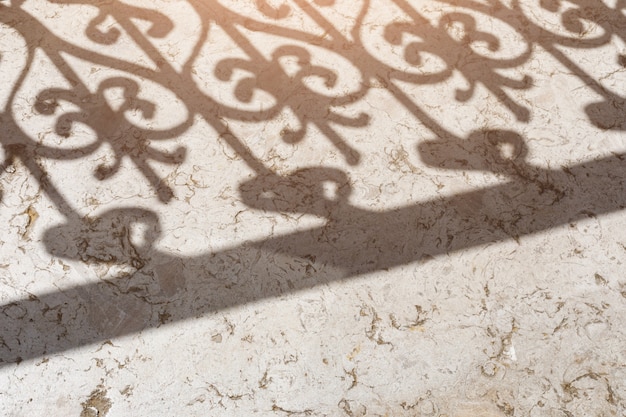 L'ombra della grata del balcone sul pavimento di pietra