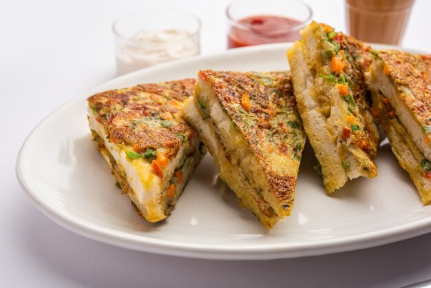 L'omelette di pane è una colazione veloce e facile dall'India. Fette di pane fresco immerse nella pastella di uova con spezie e fritte poco profonde. servito con ketchup e tè