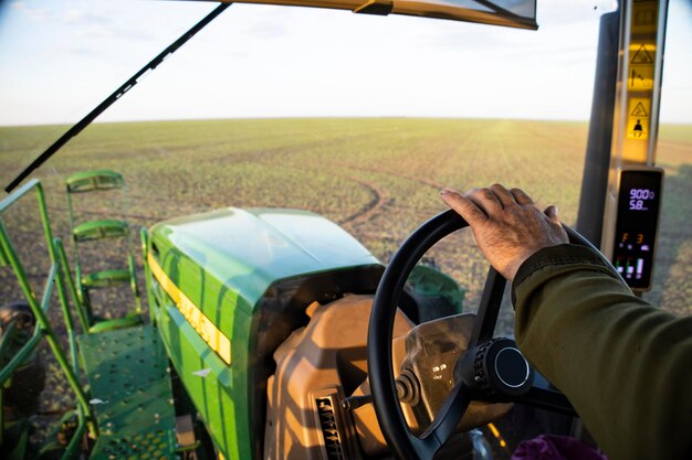 L'operatore del trattore speciale lavora i campi agricoli. Primo piano del conducente del trattore