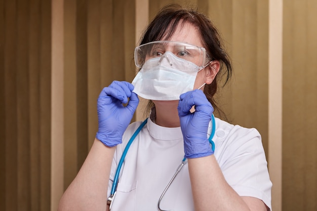 L'operatore sanitario indossa una maschera facciale durante una pandemia di covid 19.