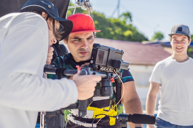 L'operatore Steadicam e il suo assistente preparano la fotocamera e lo stabilizzatore a 3 assi per una ripresa commerciale