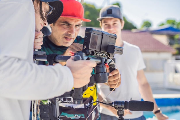 L'operatore Steadicam e il suo assistente preparano la fotocamera e lo stabilizzatore a 3 assi per una ripresa commerciale