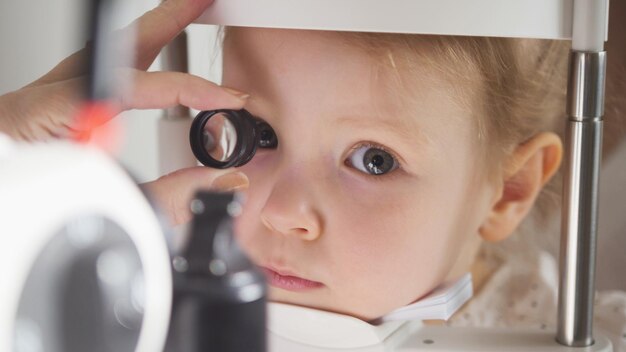 L'optometrista del medico di oftalmologia del bambino controlla la vista per la bambina