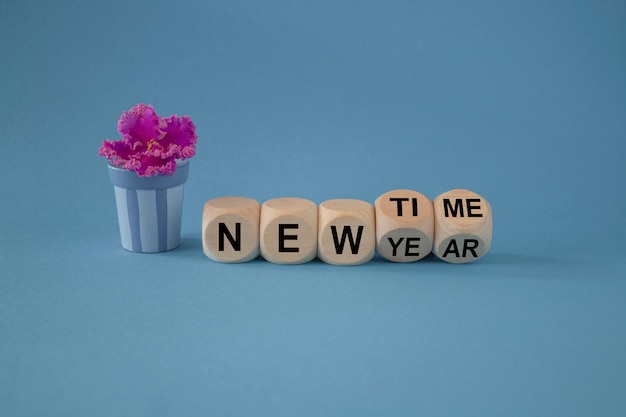 L'ora del nuovo anno ha girato un cubo e ha cambiato le parole nuovo anno in nuovo tempo bellissimo sfondo blu