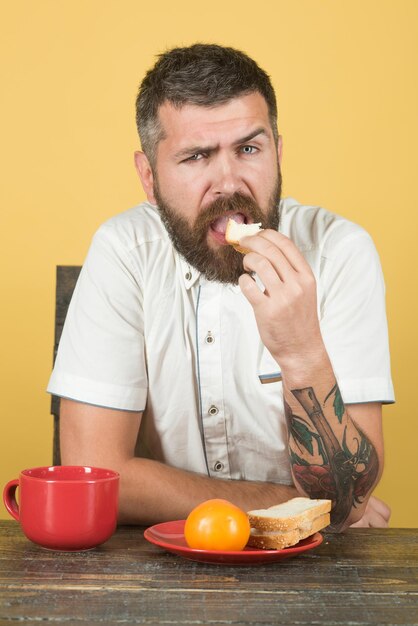 L'ora della colazione colazione pranzo cena cena uomo barbuto mangia dal piatto rosso ora del caffè