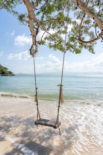 L'oscillazione pende dall'albero tropicale sopra il mare della spiaggia di sabbia di estate nell'isola di Koh Phangan, Tailandia. Estate, viaggi, vacanze e concetto di vacanza