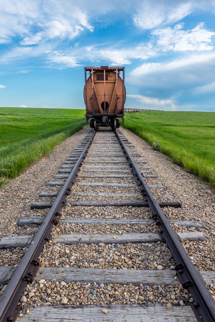 L'ultimo vagone in una lunga fila con la pista in primo piano nelle zone rurali Saskatchewan, Canada