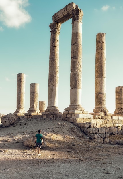 L'uomo a tutta lunghezza alle vecchie rovine contro il cielo