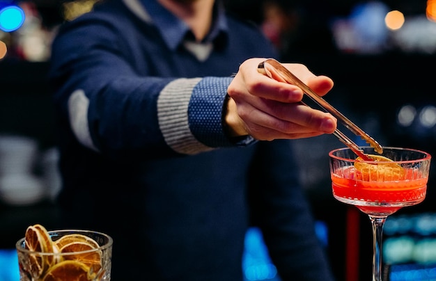 L'uomo a un evento festivo un tavolo con del cibo inzuppa una fetta di limone nella marmellata rossa