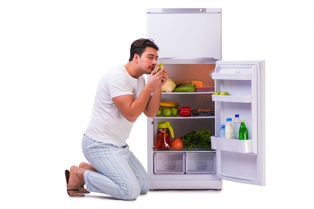 L'uomo accanto al frigo pieno di cibo