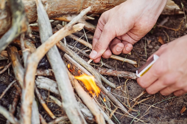 L'uomo accende un fuoco nel bosco estivo