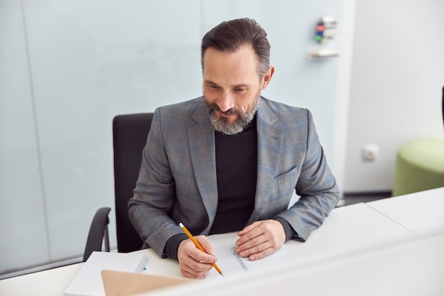 L'uomo adulto sta lavorando in un ufficio moderno