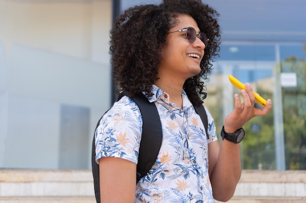 L'uomo afro invia una nota vocale con il suo smartphone all'aria aperta