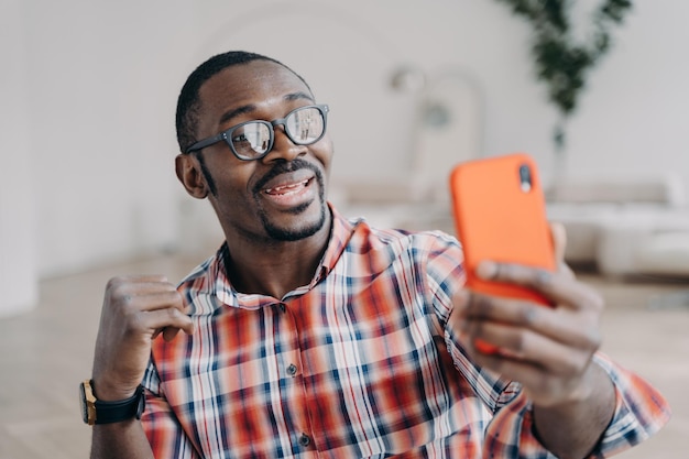 L'uomo afro positivo ha una videochiamata sullo smartphone Guy rimane a casa e conversa online