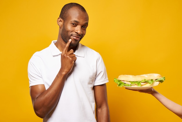 L'uomo afroamericano pensa a mangiare il panino.