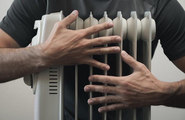 L'uomo amante del calore abbraccia la stufa. Tema della stagione di riscaldamento