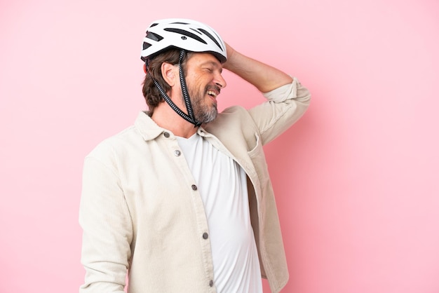 L'uomo anziano olandese con casco da bici isolato su sfondo rosa ha realizzato qualcosa e intendeva la soluzione