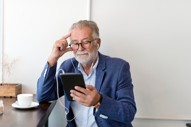 L&#39;uomo anziano sta usando la tavoletta digitale