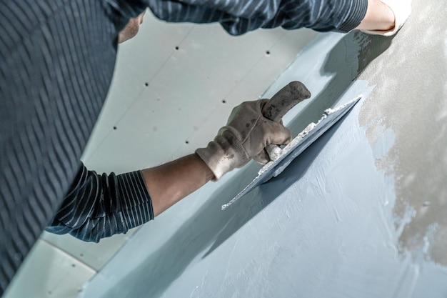 L'uomo applica l'isolamento a una parete del bagno