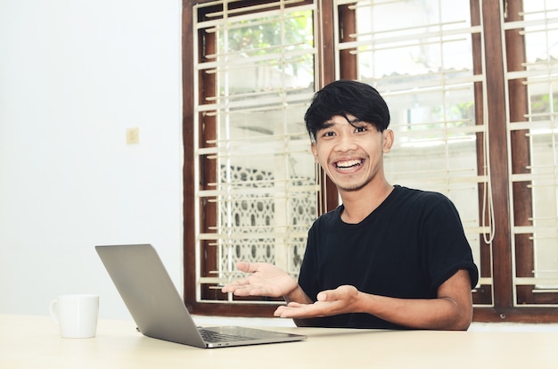 L'uomo asiatico era seduto indicando il laptop