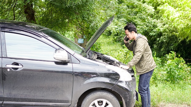 L'uomo asiatico ha aperto il cofano dell'auto durante la chiamata