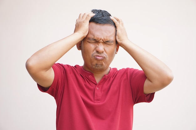 L'uomo asiatico ha uno stress da mal di testa dal lavoro