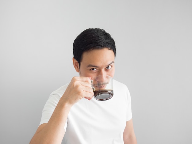 L&#39;uomo asiatico in maglietta bianca beve una tazza di caffè.