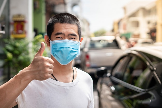 L'uomo asiatico indossa una maschera chirurgica