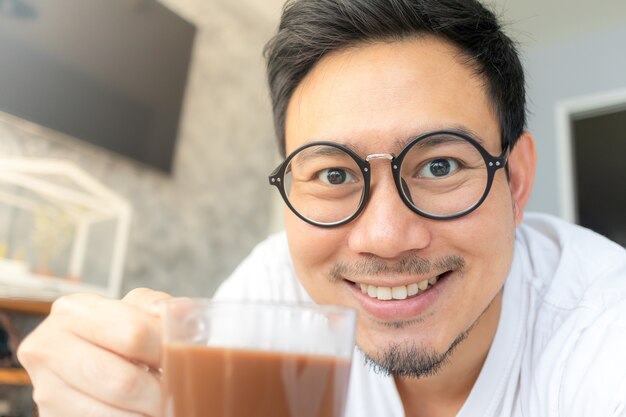 L&#39;uomo asiatico selfy beve il caffè.