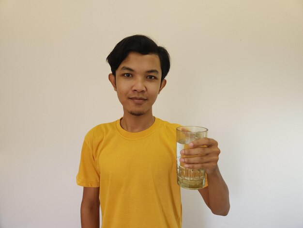 L'uomo asiatico sta bevendo acqua isolata su sfondo bianco