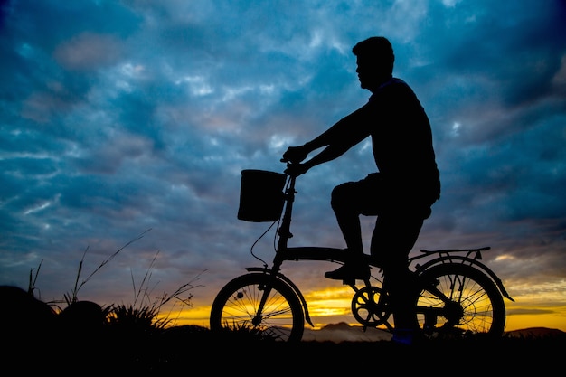 L'uomo asiatico va in bicicletta al mattino.