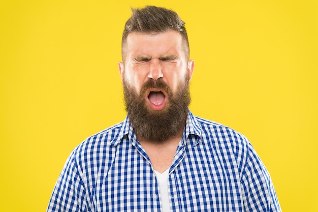 L'uomo barbuto hipster con starnuti viso chiuso gli occhi si chiudono su sfondo giallo. Starnuti brutali di hipster. Concetto di allergia. Prendi farmaci per le allergie. Non riesco a smettere di starnutire. Sto per starnutire.