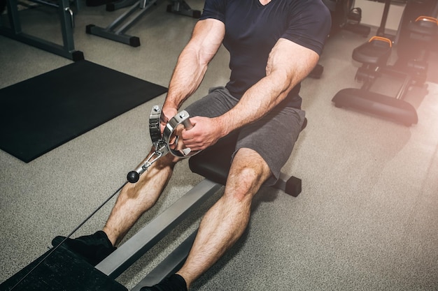 L'uomo barbuto si sta allenando in palestra con i pesi Un bel ragazzo sta facendo esercizi per buoni muscoli Il personal trainer di fitness è al lavoro Motivazione sportiva Stile di vita sano Bodybuilder in forma