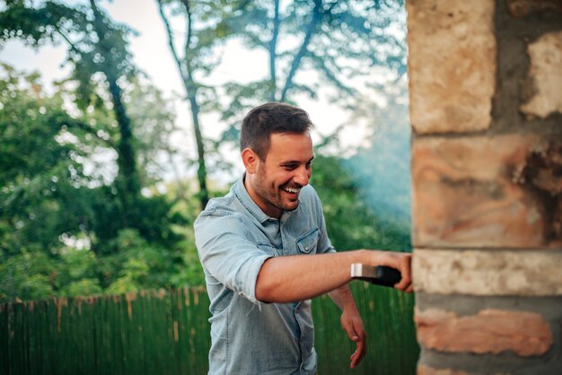 L&#39;uomo bello si diverte a fare il barbecue.