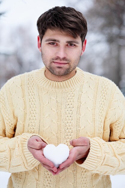 L'uomo bello tiene un cuore di neve