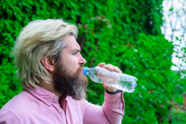 L'uomo beve acqua all'aperto uomo con bottiglia d'acqua stile di vita sano concetto di assistenza sanitaria acqua potabile