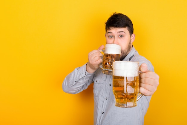 L'uomo beve birra e offre allo spettatore un bicchiere di birra