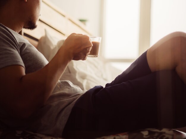 L&#39;uomo beve caffè caldo e si rilassa nella sua stanza.