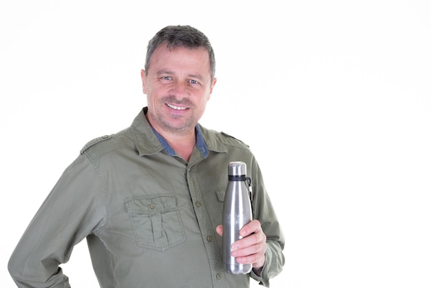 L'uomo beve dalla bottiglia metallica grigia in alluminio nelle mani da parte copia spazio su sfondo bianco