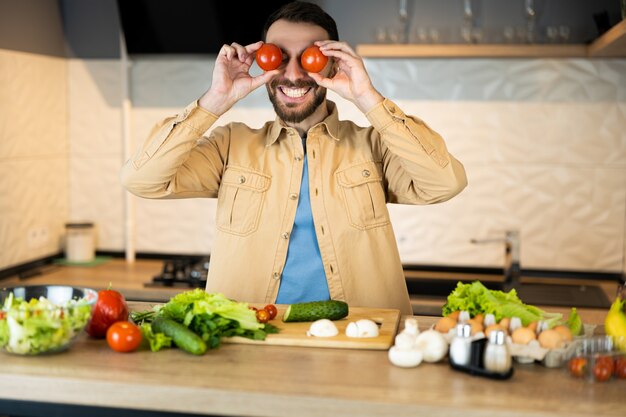 L'uomo bianco con la barba sorride e si diverte in cucina.