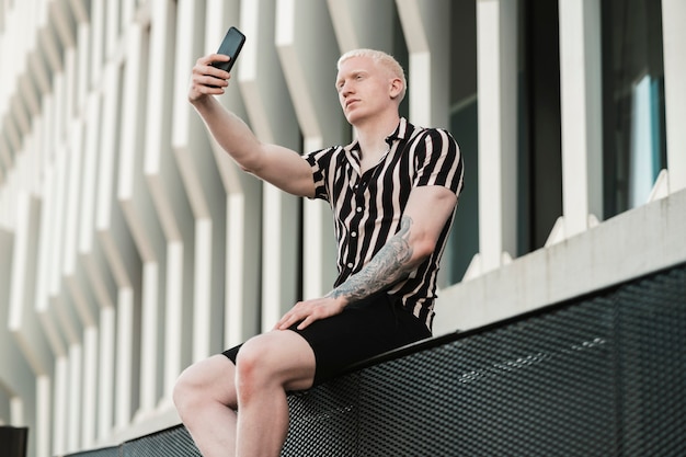 L'uomo biondo caucasico si fa un selfie per strada