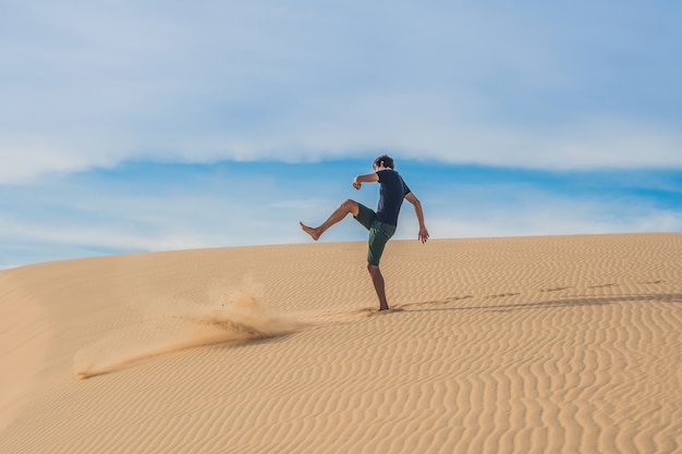 L'uomo calcia la sabbia, fastidio, aggressione nel deserto del Vietnam