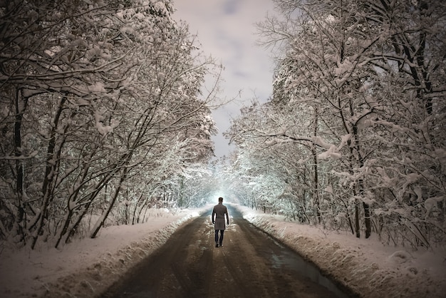 L'uomo cammina sulla strada forestale. sera notte