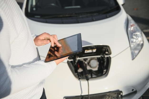 L'uomo carica un'auto elettrica alla stazione di ricarica