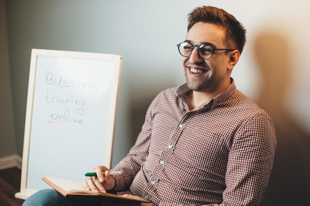 L'uomo caucasico con gli occhiali sta parlando e sorride mentre tiene corsi di business online