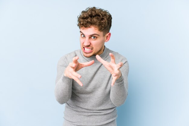 L'uomo caucasico dei giovani capelli ricci biondi ha isolato il ribaltamento che grida con le mani tese.