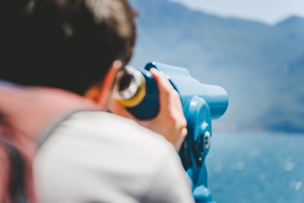 L'uomo caucasico sta guardando curiosamente attraverso il binocolo