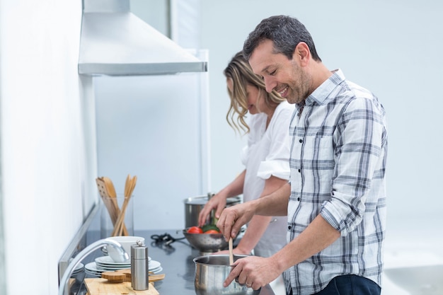 L&#39;uomo che aiuta la donna incinta prepara l&#39;alimento in cucina