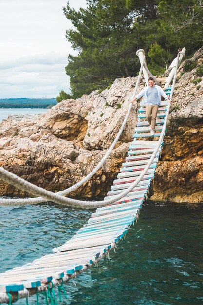 L'uomo che cammina dal ponte sospeso attraversa il mare adriatico