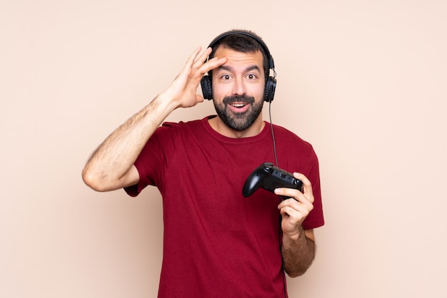 L'uomo che gioca con un controller per videogiochi su un muro isolato ha appena realizzato qualcosa e ha intenzione di risolverlo